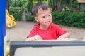 Asian 3 - 4 years old toddler boy child having fun climbing on artificial boulders in playground at the park Royalty Free Stock Photo