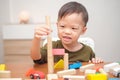 Asian 2 - 3 years old toddler boy child having fun playing with wooden building block toys indoor Royalty Free Stock Photo