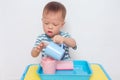 Asian 2 years old toddler boy child having fun pouring water into cup, Wet Pouring Montessori