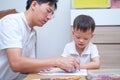 Asian 2 - 3 years old toddler boy child painting with crayons, kid coloring with father at home Royalty Free Stock Photo