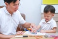 Asian 2 - 3 years old toddler boy child painting with crayons, kid coloring with father at home, Dad spending quality time with Royalty Free Stock Photo