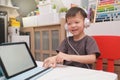 Asian 4 years old toddler boy child using tablet pc computer, Child at home during the Covid-19 health crisis, Distance Learning, Royalty Free Stock Photo