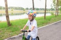 Asian 3 - 4 years old toddler boy child wearing safety helmet learning to ride first balance bike in sunny summer day Royalty Free Stock Photo