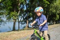 Asian 3 - 4 years old toddler boy child wearing safety helmet learning to ride first balance bike in sunny summer day, kid playing Royalty Free Stock Photo