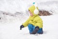 Asian 2 - 3 years old toddler boy kid wearing earmuff, snow gloves playing happily in snow Royalty Free Stock Photo