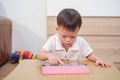 Asian 2 - 3 years old toddler boy using tablet pc playing game, watching a video from tablet pc. Gadget-addicted kid