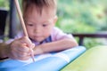 Asian 2 years old toddler boy writing / drawing with pencil, Preschooler doing homework Royalty Free Stock Photo