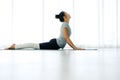 Asian yogi woman practicing yoga concept, stretching in Cobra exercise, Bhujangasana pose, working out, indoor Royalty Free Stock Photo