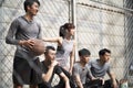 Asian young adults resting relaxing on outdoor basketball court Royalty Free Stock Photo