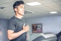 Asian young atheletic man in sportswear running on treadmill at gym