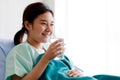 An asian young beautiful female patient lying on bed in the hospital, holding a glass and drinking water. Medical Treatment and Royalty Free Stock Photo