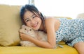 Asian young beautiful female teenager girl in sexy dress lying down on cozy sofa Royalty Free Stock Photo