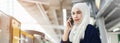Asian young beautiful muslim woman calling telephone on skytrain station, banner size