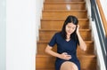 Asian young beautiful pregnant woman sitting with hand touching her tummy at home,Happy mood and smiling Royalty Free Stock Photo