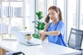 Asian young beautiful professional successful female doctor in blue uniform with stethoscope sitting smiling taking coffee break Royalty Free Stock Photo