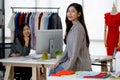 Asian young beautiful successful confident stylish female fashion designer in casual suit stand smiling look at camera while woman Royalty Free Stock Photo