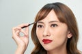 Asian young beautiful woman applying cosmetic powder brush on eyebrow, natural makeup, beauty face Royalty Free Stock Photo