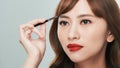 Asian young beautiful woman applying cosmetic powder brush on eyebrow, natural makeup, beauty face Royalty Free Stock Photo