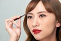 Asian young beautiful woman applying cosmetic powder brush on eyebrow, natural makeup, beauty face Royalty Free Stock Photo