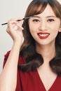 Asian young beautiful woman applying cosmetic powder brush on eyebrow, natural makeup, beauty face Royalty Free Stock Photo