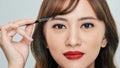 Asian young beautiful woman applying cosmetic powder brush on eyebrow, natural makeup, beauty face Royalty Free Stock Photo
