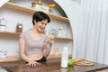 Asian young beautiful woman drinking glass of milk in kitchen at home. health care concept Royalty Free Stock Photo