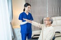 Asian young beautiful woman nurse care at nursing home take care disable senior elderly man by serve physical therapy for older p Royalty Free Stock Photo