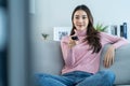 Asian young beautiful woman watching fun movie on television at home. Attractive casual girl feel happy and relax, sit on sofa Royalty Free Stock Photo