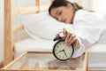 Asian young beauty woman turning off alarm clock in morning late without looking clock and lazy to working on in holiday. Bedroom Royalty Free Stock Photo