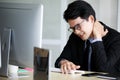 Asian young black short hair male employee worker wears formal suit with necktie gray shirt and eyeglasses has office syndrome