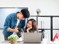 Asian young blogger couple looking photos in a camera for promote travel content on social network and channel in the studio white Royalty Free Stock Photo