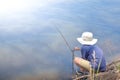 Asian young boy fishing by river using bamboo fishing rod on beautiful water surface and sunrise,Lifestyle of asian children, Royalty Free Stock Photo