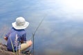 Asian young boy sitting fishing by river using bamboo fishing rod on beautiful water surface and sunrise,Lifestyle of asian Royalty Free Stock Photo