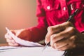 Asian young business man of student holding a pen writing letter on paper at home