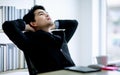 Asian young business man wearing formal black suit and necktie, getting tired or exhausted, stretching his body and taking rest Royalty Free Stock Photo