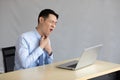 Asian young businessman have a sore throat in office