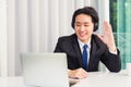 Asian young businessman smile wearing headphones and suit video conference call Royalty Free Stock Photo