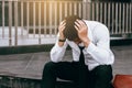 Asian young businessman stress sitting in front of with his hand