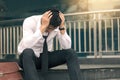 Asian young businessman stress sitting in front office with his hands covering his head against Royalty Free Stock Photo