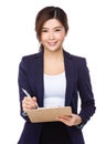 Asian Young businesswoman take note on clipboad Royalty Free Stock Photo