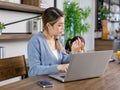 Asian young cheerful female mother and little cute girl daughter sitting smiling watching streaming movie online via laptop Royalty Free Stock Photo