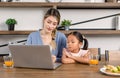 Asian young cheerful female mother and little cute girl daughter sitting smiling watching streaming movie online via laptop Royalty Free Stock Photo