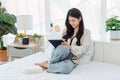 Asian young cheerful female teenage model sitting smiling on white clean sheet bed using pen with touchscreen tablet computer Royalty Free Stock Photo