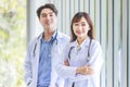 Asian young cheerful professional male and female intern practitioner doctor colleague in white lab coat uniform with stethoscope Royalty Free Stock Photo