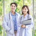 Asian young cheerful professional male and female intern practitioner doctor colleague in white lab coat uniform with stethoscope Royalty Free Stock Photo