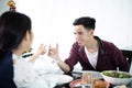 Asian young couple enjoying a romantic dinner  evening drinks while sitting at the dinning table on the kitchen together Royalty Free Stock Photo