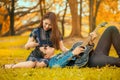 asian young couple in love enjoy man playing guitar lying on girlfriend legs in the garden autumn park with sun light