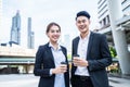 Asian young couple office business people stand outdoor in city with confident face holding hot coffee. Working man and woman feel Royalty Free Stock Photo