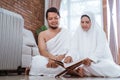 Asian young couple praying with Al-Qur`an and prayer beads