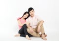 Asian young couple sitting on floor isolated on white background Royalty Free Stock Photo